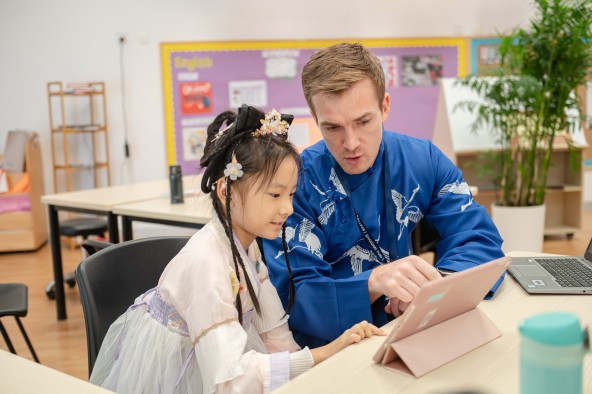 Student and teacher working with laptop